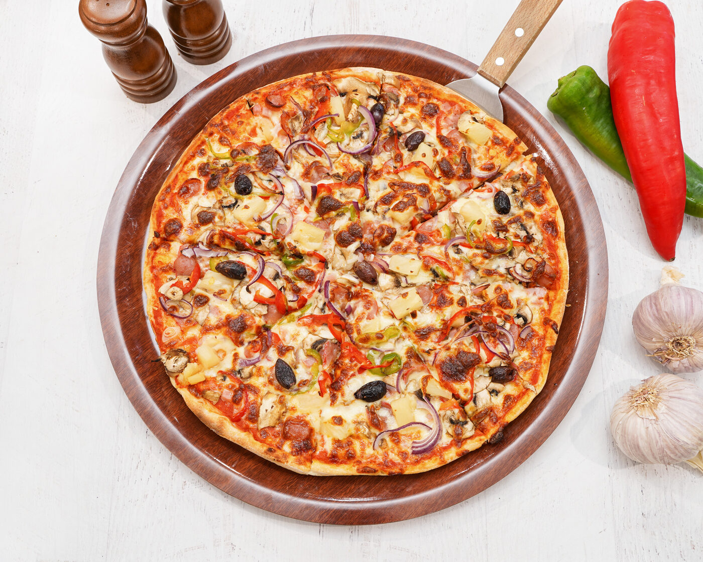 Loaded supreme-style pizza with ham, capsicum, olives and pineapple