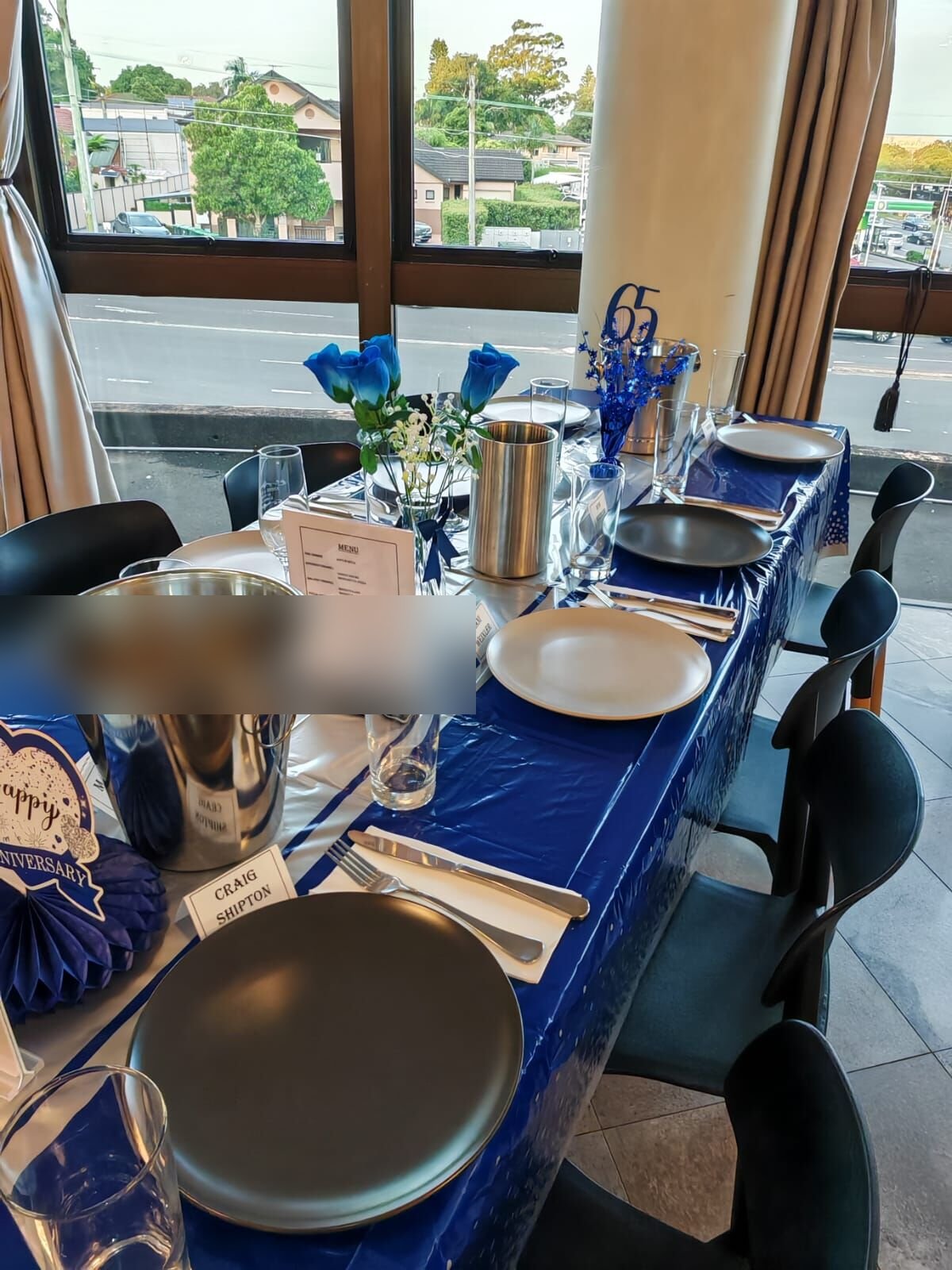 Long banquet tables set with blue linen for a celebration in the upstairs function room